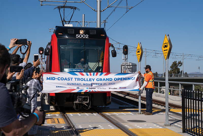Attendees cheer during a ceremonial banner breaking at the UC San Diego Central Campus Trolley Station