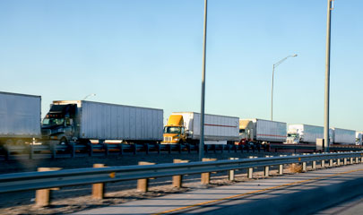 A long line of semi trucks waiting to cross the border from the United States into Mexico.